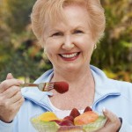 Senior woman eating a fruit salad.